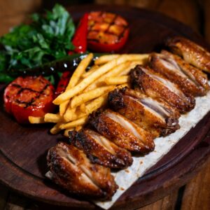 Mouth-watering grilled chicken wings with fries,